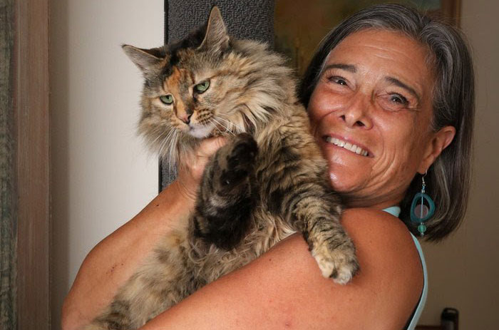 Jenifer Firestone, inventor of Kiwi's Climber holding her cat Kiwi